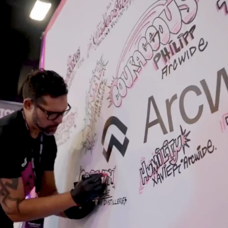Arcwide event illustration wall with man writing on it